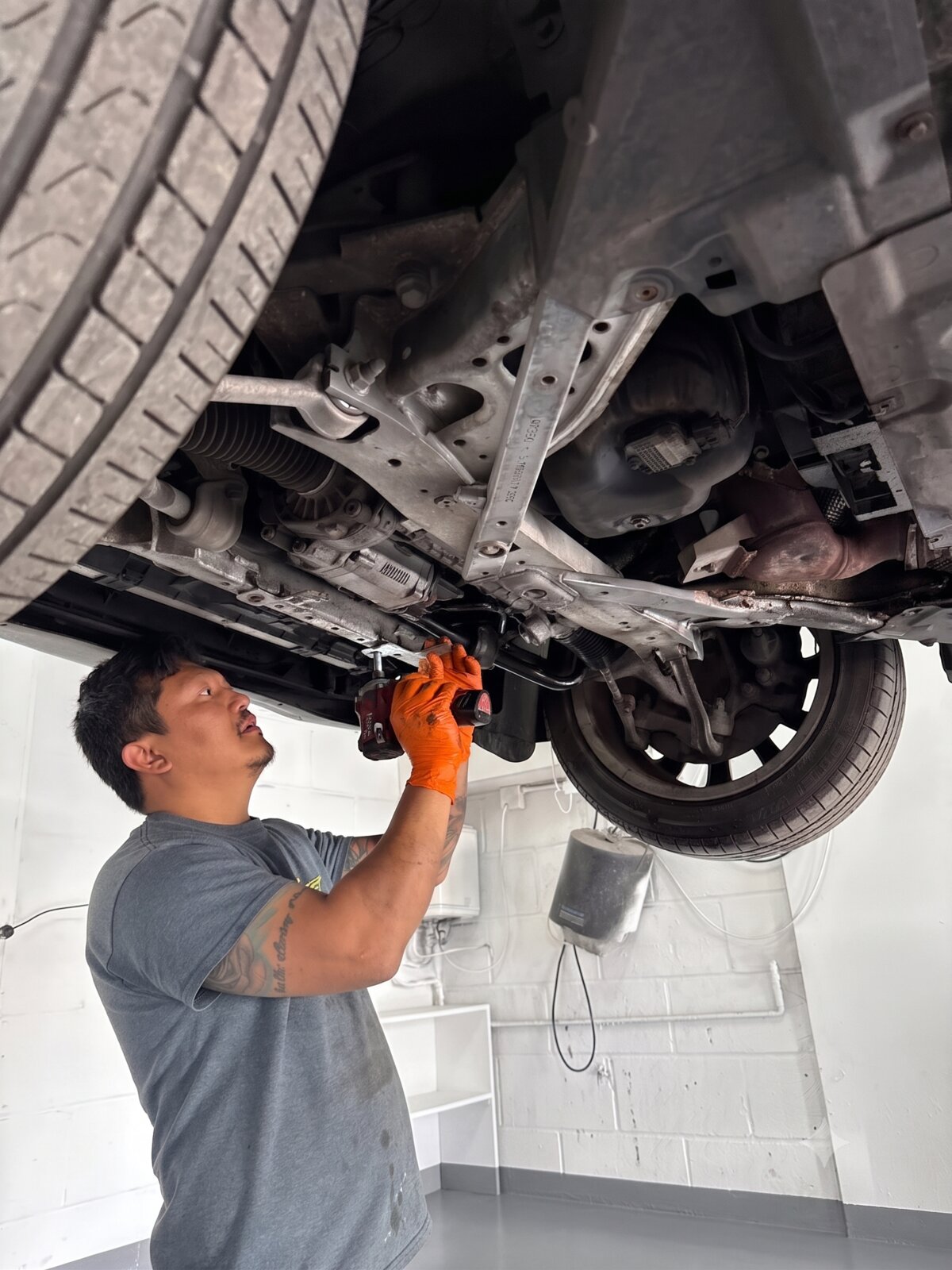Yogi Garage mechanic working under raised vehicle